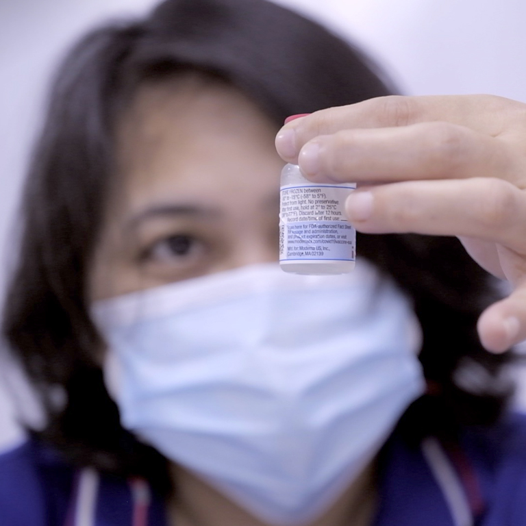 Filipina Healthcare Worker Inspects COVID-19 Vaccine Vial