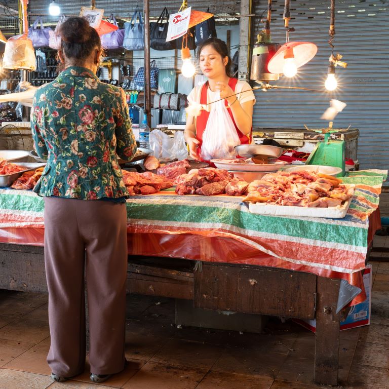 A woman buys meat at a fresh market in Vientiane, Laos. 