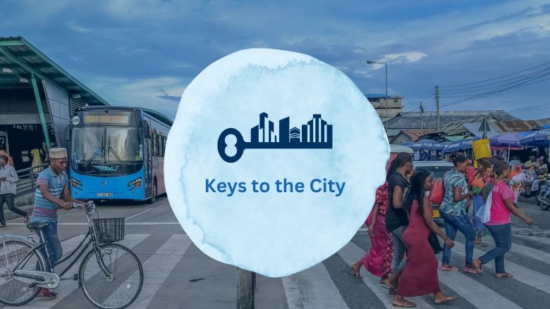 Keys to the city graphic over a busy crosswalk in Tanzania with people crossing the street