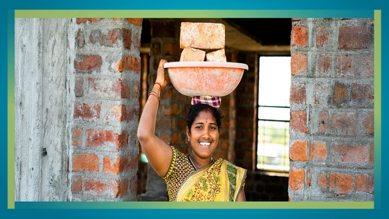 Female construction worker carrying bricks