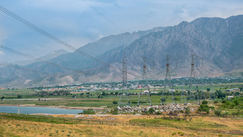 High-voltage power towers near the Zeravshan mountains in Uzbekistan.