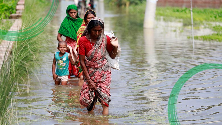 Women walking through a flooded area Women walking through a flooded area